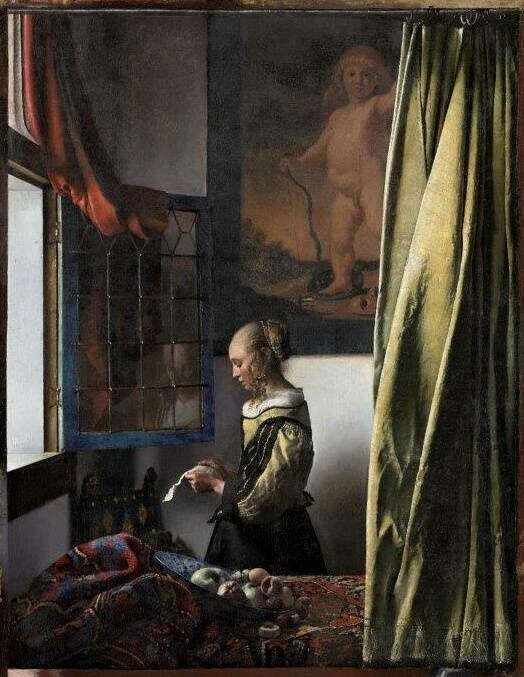 Frau am offenen Fenster liest einen Brief mit getrübtem Blick